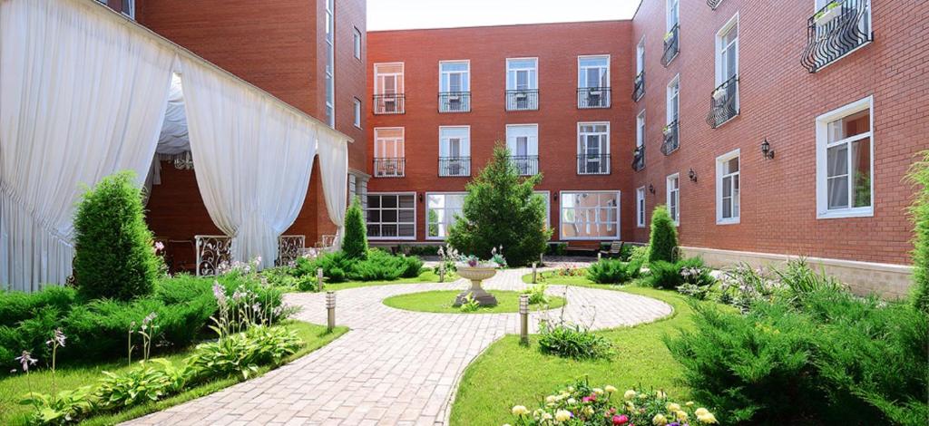 a garden in front of a brick building at Hotel Imperial Wellness & SPA in Obninsk