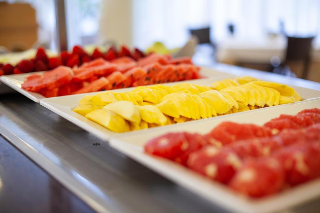 a buffet with two trays of different types of fruit at Grupotel Playa Club in Son Xoriguer