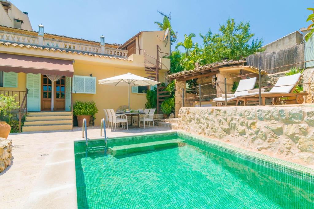 een villa met een zwembad en een huis bij Es Raco in Caimari