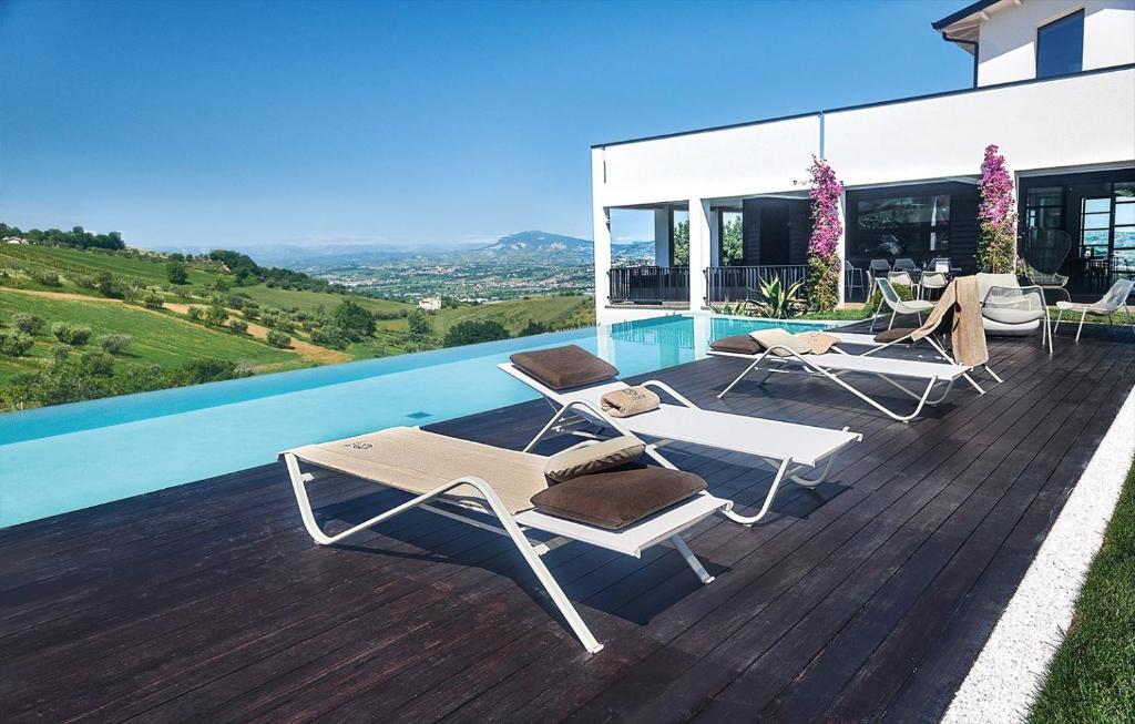 a pool with two lounge chairs on a wooden deck at Idea 18 Boutique Hotel in Controguerra