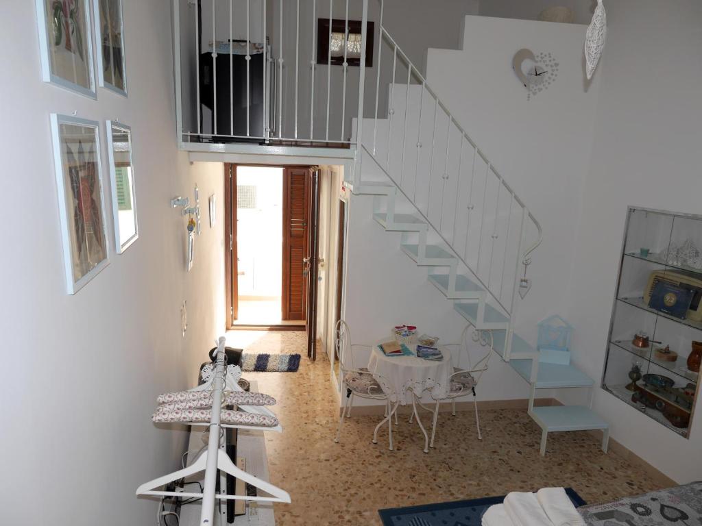 ポリニャーノ・ア・マーレにあるLa Casa Di Nicoleのテーブルと階段のある部屋の階段