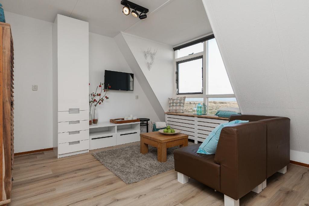 een woonkamer met een bank en een tv bij Perfect Stay Holiday, Sea View in Egmond aan Zee