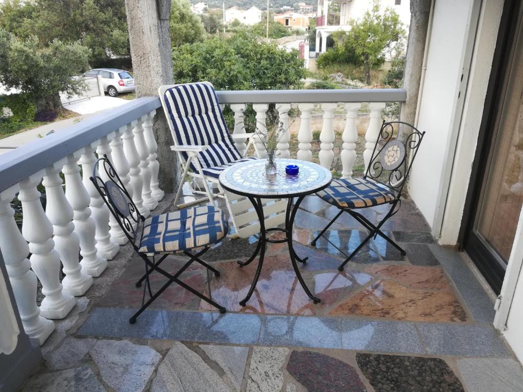 two chairs and a table on a balcony at Apartmani Parlov in Vinišće