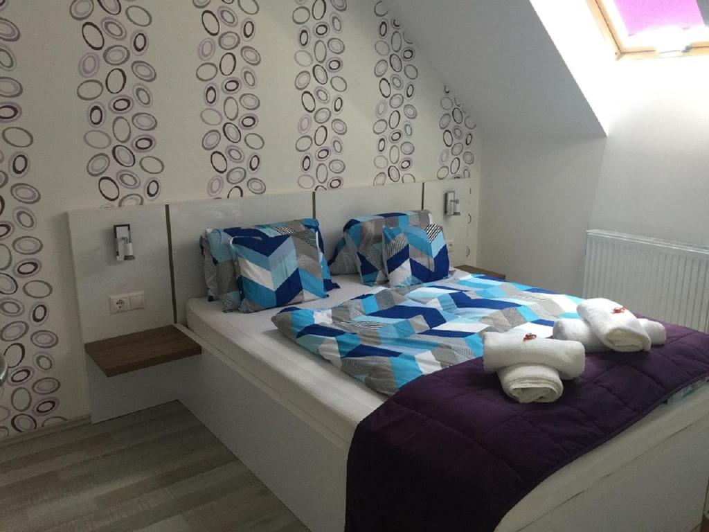 un dormitorio con una cama con dos animales de peluche en ALOE Apartman, en Sárvár