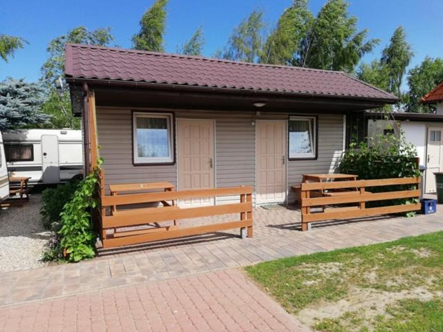 a small house with two benches in front of it at Domek letniskowy Mauritius in Mielno