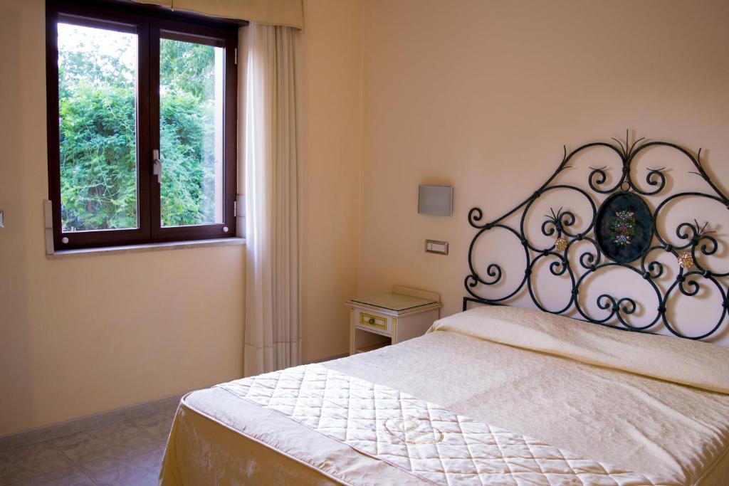 sypialnia z łóżkiem z zagłówkiem z kutego żelaza w obiekcie Hotel Ginevra w mieście Poggiomarino