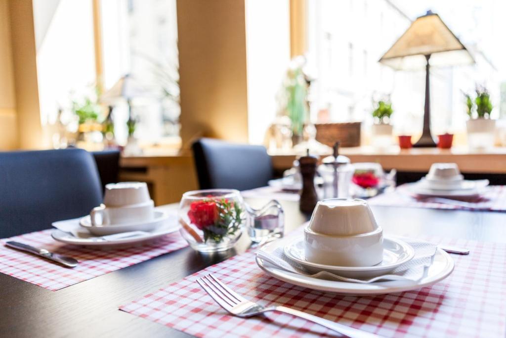 uma mesa com pratos e guardanapos em cima em Hotel Cavalier em Bruges