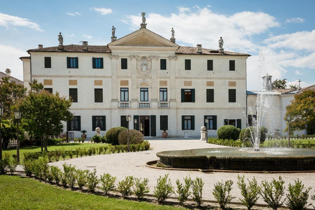 un grande edificio bianco con una fontana di fronte di Villa Volpi a Mogliano Veneto