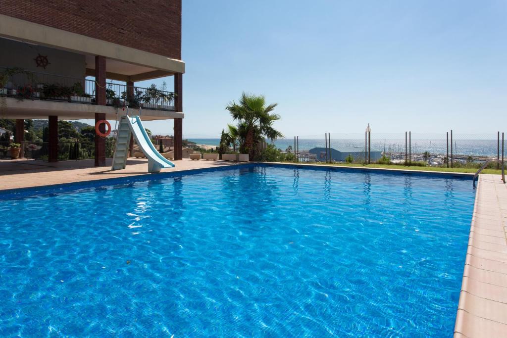 una piscina con scivolo in un edificio di Tranquilidad junto al mar con piscina a Sant Andreu de Llavaneres
