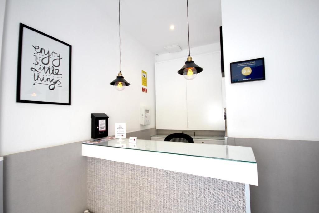 a kitchen with a white counter and pendant lights at Hospedaria Buganvilia Alvor in Alvor