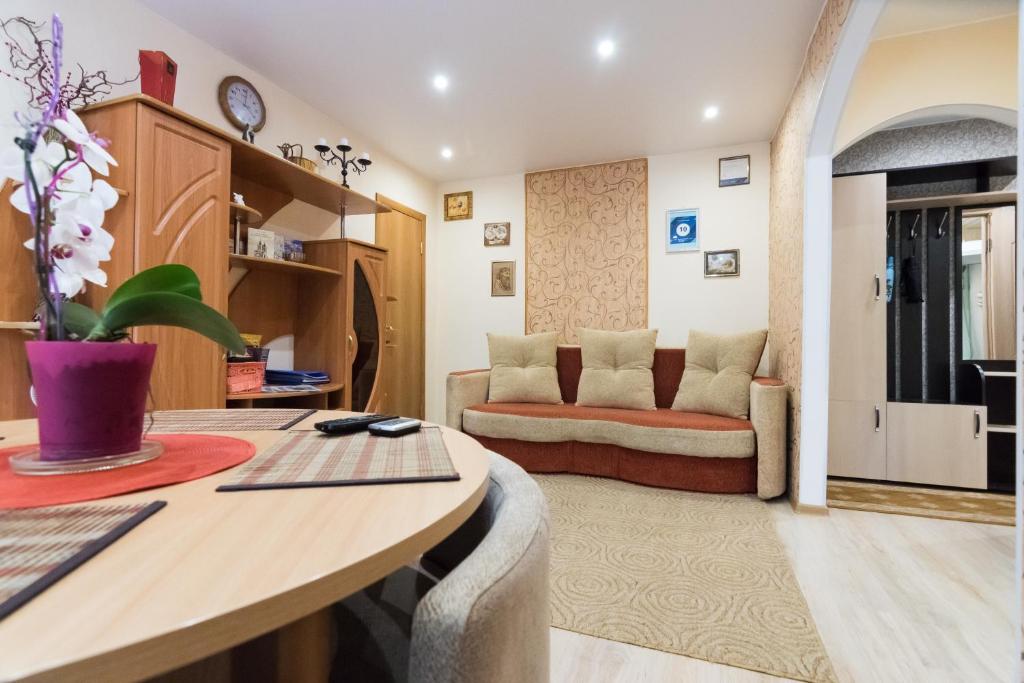 a living room with a table and a couch at Apartment Olovyanka in Velikiy Novgorod