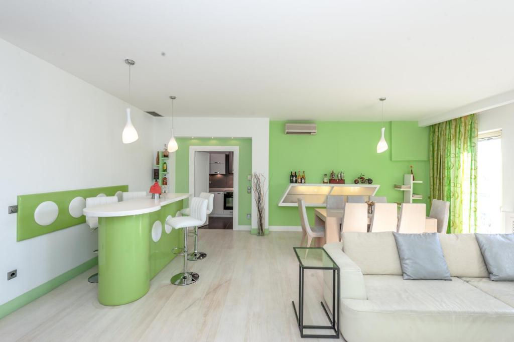 a living room with green walls and a white couch at Corfu Overview Penthouse in Corfu
