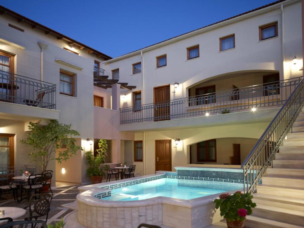 a hotel with a swimming pool in front of a building at Palazzo Vecchio Exclusive Residence in Rethymno
