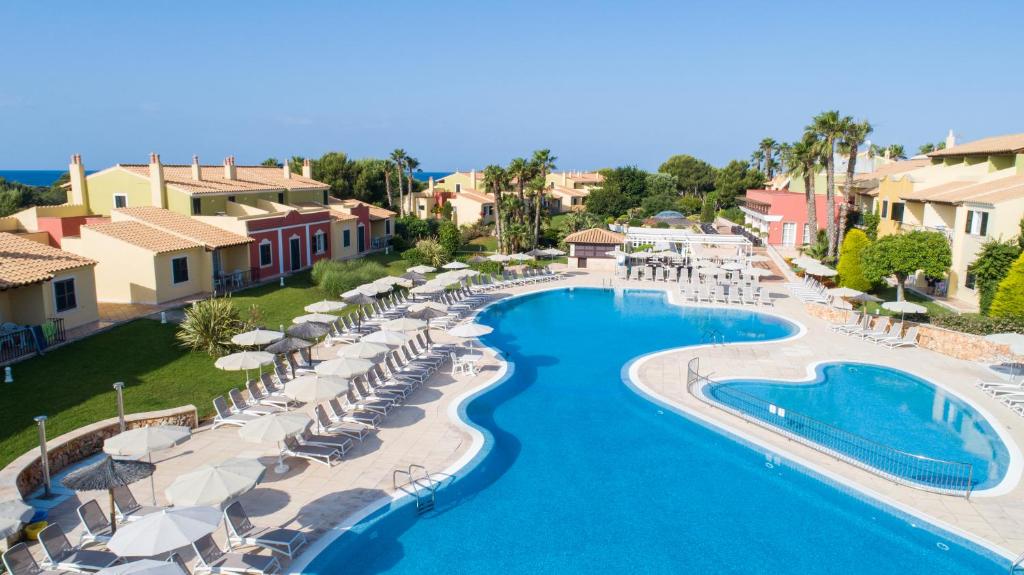 an aerial view of a resort pool with umbrellas and chairs at Grupotel Playa Club in Son Xoriguer