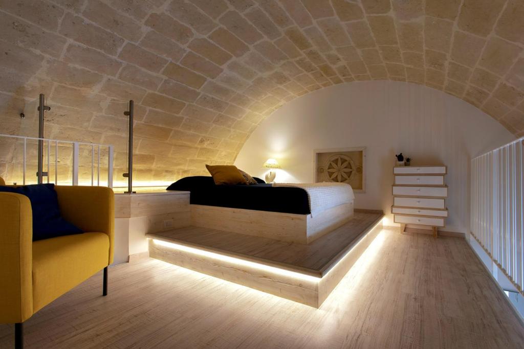 - une chambre avec un lit et un mur en pierre dans l'établissement Lo Strazzo - Comfort Rooms, à Matera