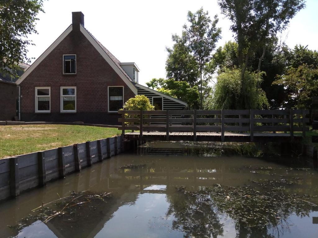 una piscina de agua frente a una casa en Breeveld Cottage en Woerden
