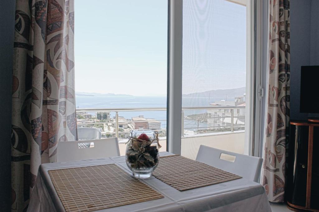 una mesa con un jarrón en una mesa con una ventana en Elti Apartment, en Sarandë