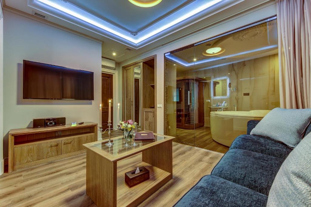 sala de estar con sofá y TV en Premium Hotel, en San Petersburgo