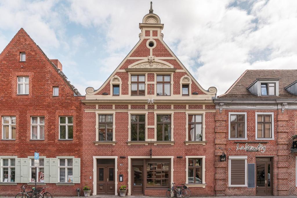 ein großes rotes Backsteingebäude mit einem Uhrturm in der Unterkunft Design Apartments - "Im Holländerhaus" in Potsdam