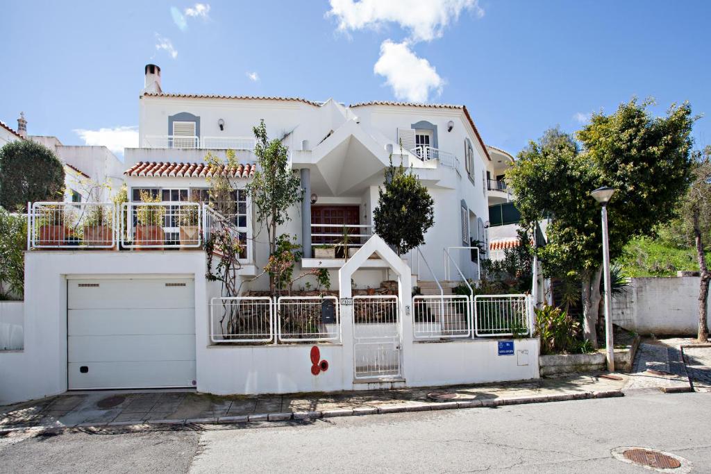 een wit huis met een poort en een garage bij Villa Monaco in Faro
