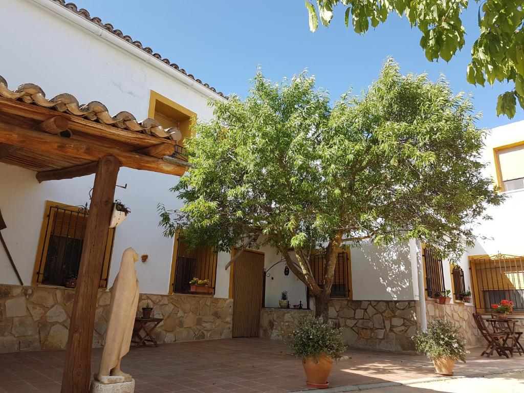 una casa con un árbol delante de ella en Casa Rural El Almendro, en Rozalén del Monte