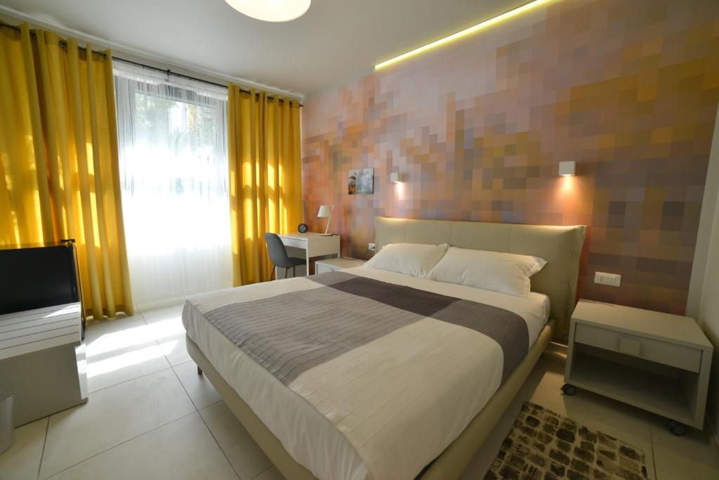 a bedroom with a large bed and a television at Hotel Villa MIKI in Bordighera