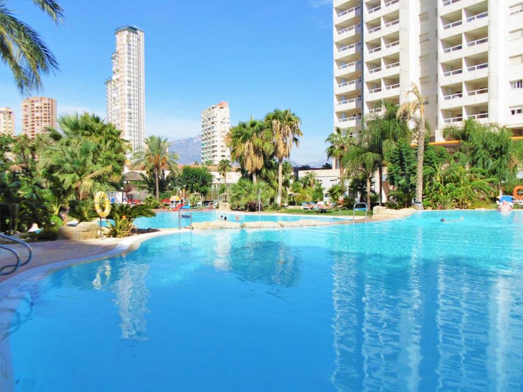 a large swimming pool with palm trees and buildings at Gemelos 22 Resort Apartment 2-15-B Levante Beach in Benidorm