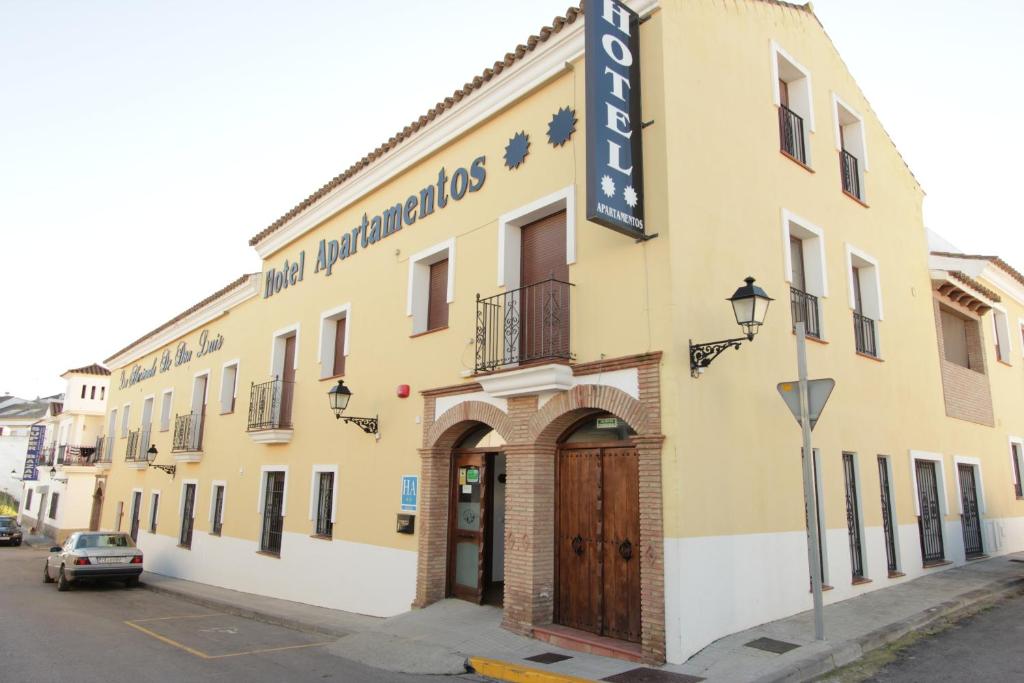 a yellow building with a sign for a hotel at La Hacienda de Don Luis in Jimena de la Frontera