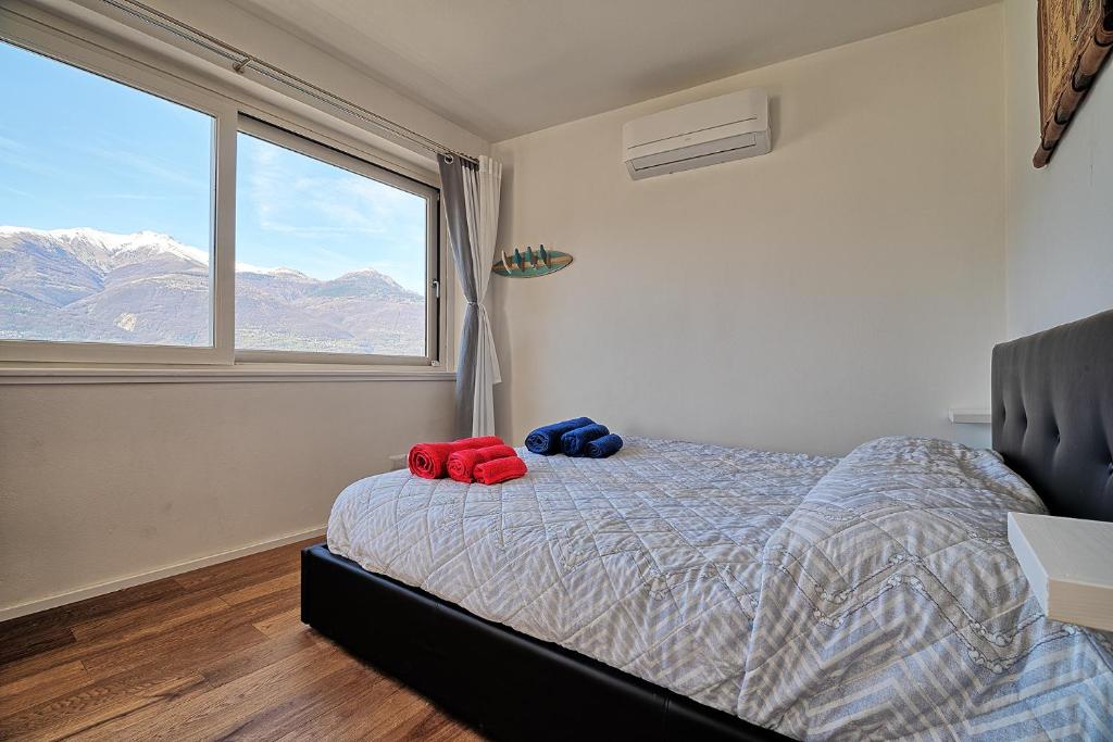 a bedroom with a bed and a large window at Marina Apartments in Colico