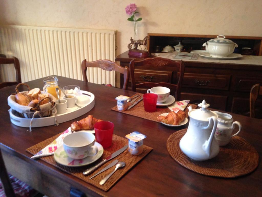 a table with a breakfast of coffee and croissants at Les Fleurs in Monpazier