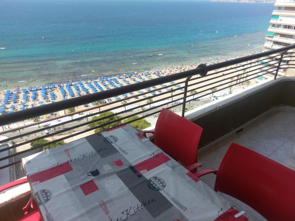 - un balcon avec une table et des chaises et la plage dans l'établissement Apartamento en Playa Levante Coblanca 8, à Benidorm