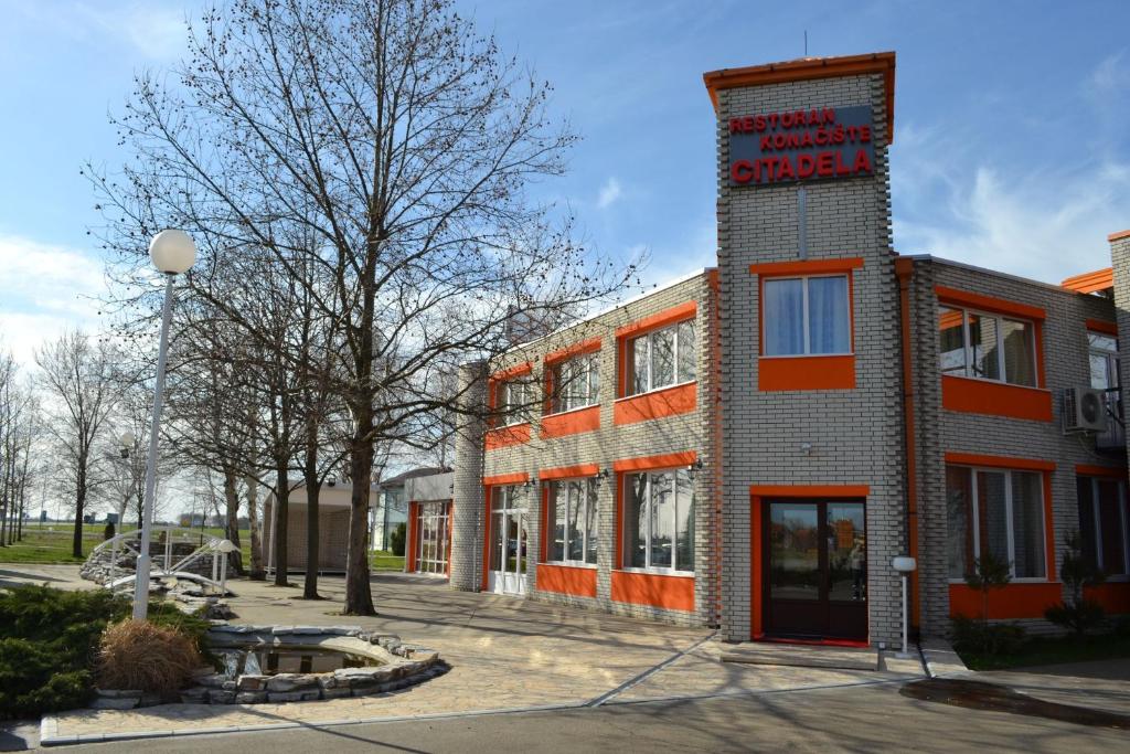 a brick building with a sign on the side of it at Motel Citadela 023 in Zrenjanin