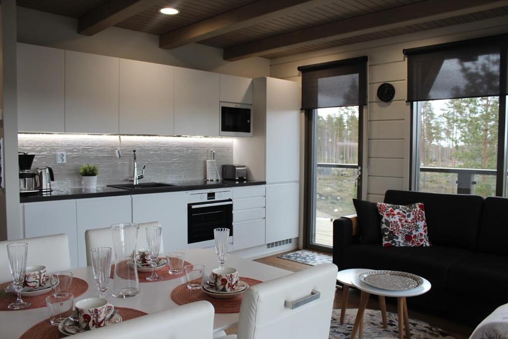 uma cozinha e sala de estar com uma mesa e um sofá em Naava Chalet Pikku Panda (305) em Ahtari