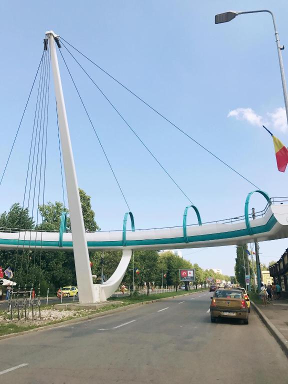 un pont sur une rue avec une voiture sur la route dans l'établissement La Pasarela, à Mamaia