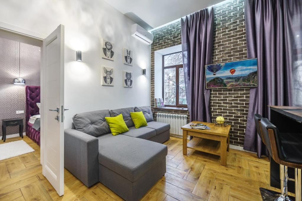 a living room with a couch and a tv at Pushkinskaya Apartments in Kyiv