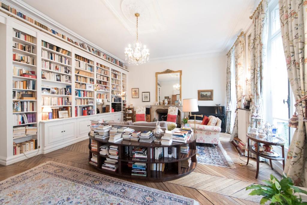 a living room with a coffee table and bookshelves at Veeve - Antique Charm by Arc de Triomphe in Paris