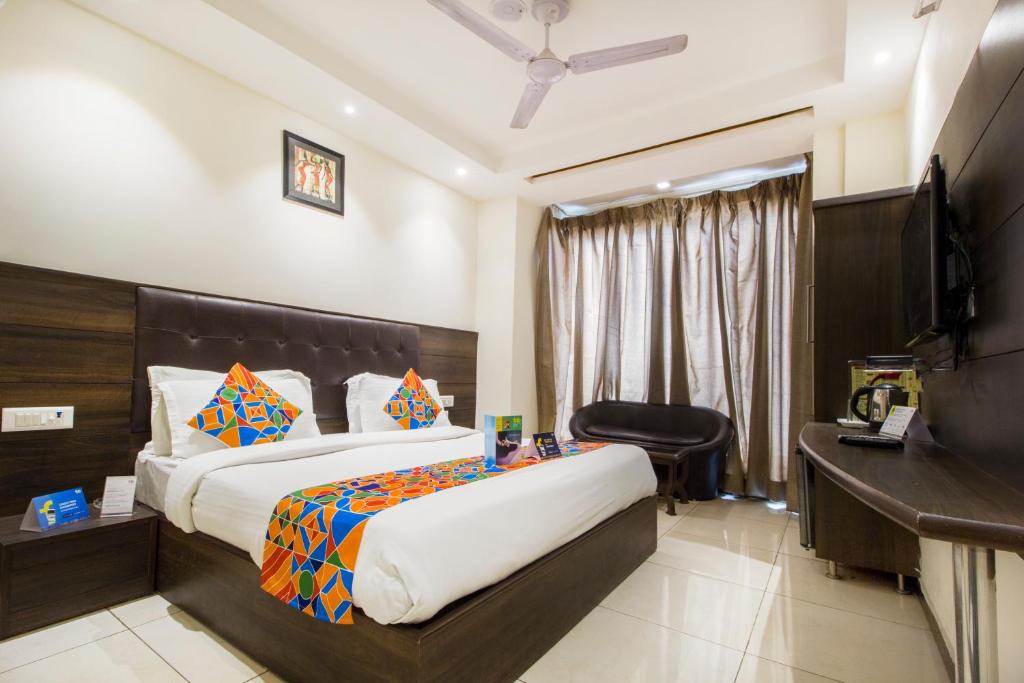 a hotel room with a bed and two nightstands at FabExpress Le Continental in New Delhi