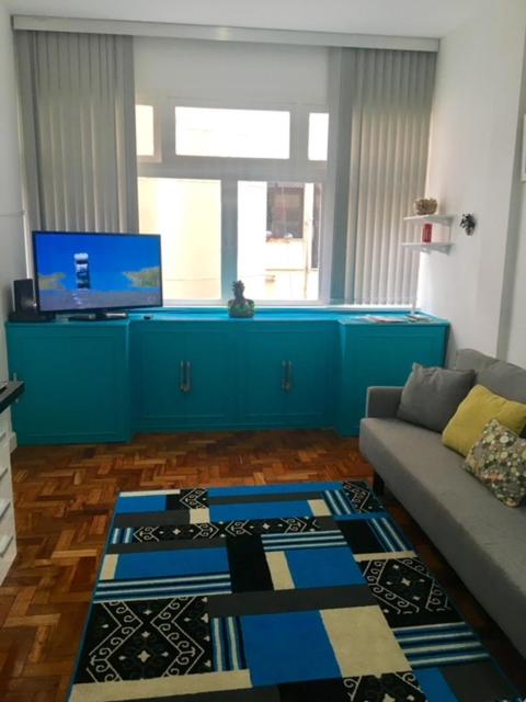 sala de estar con sofá y armario azul en Paula Freitas Copacabana, en Río de Janeiro