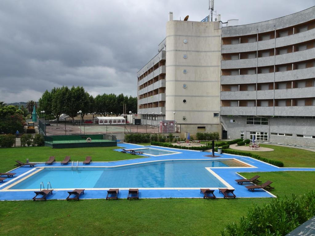 a large swimming pool in front of a building at Grande Hotel Dom Dinis in Mirandela