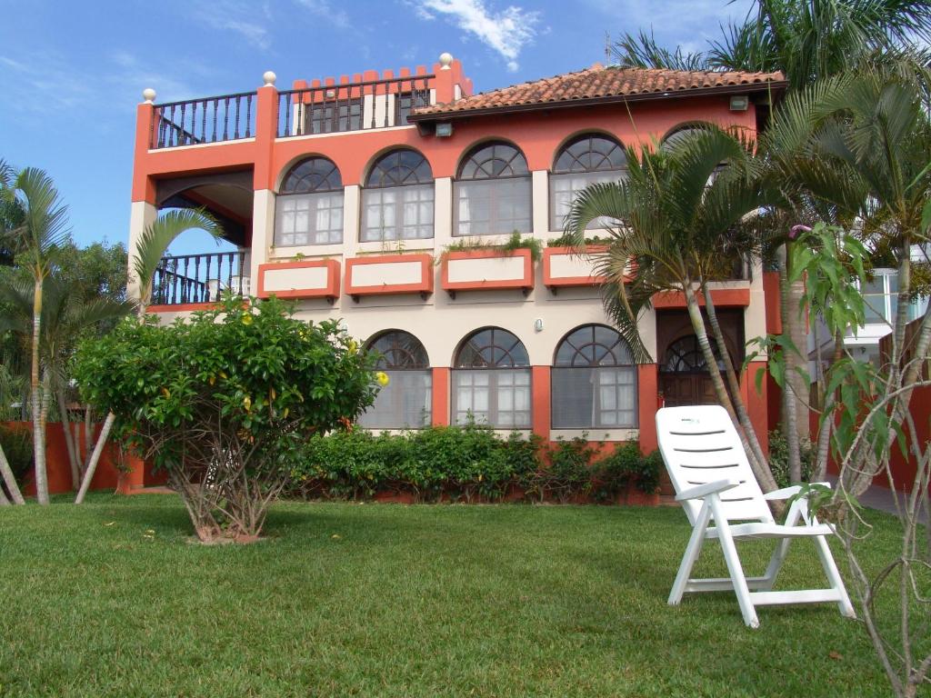 un par de sillas blancas delante de una casa en La Alhambra Apart Hotel, en Florianópolis