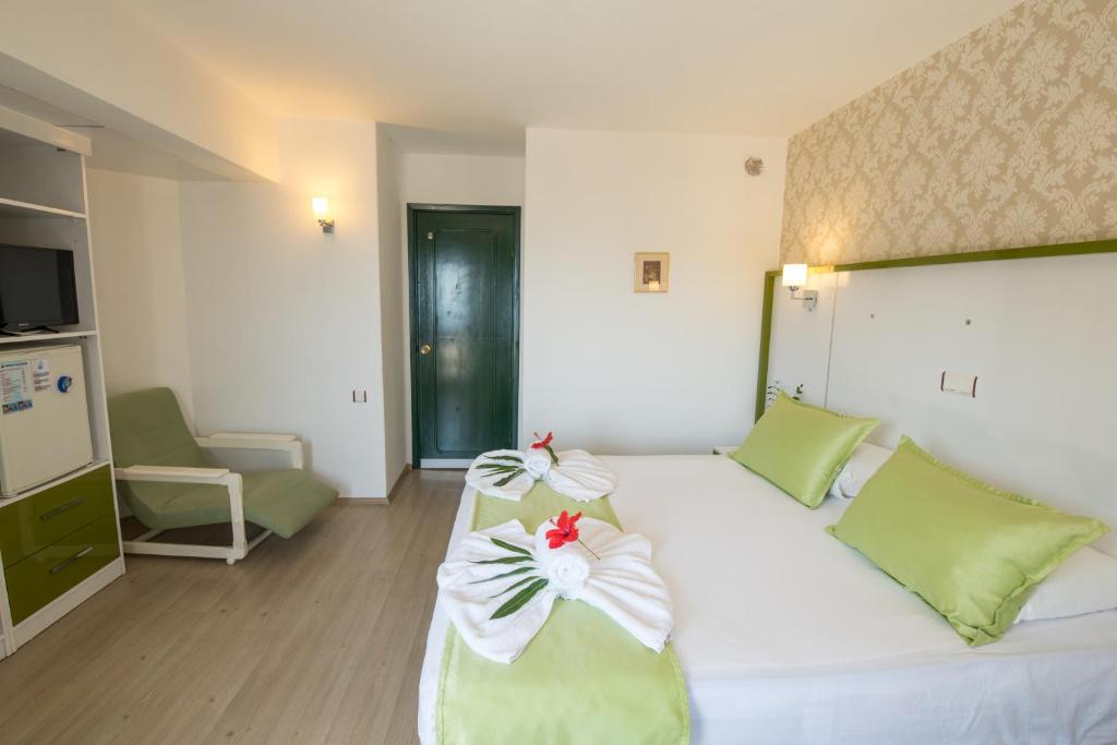 a bedroom with a large white bed with flowers on it at Hotel Pirat in Kalkan
