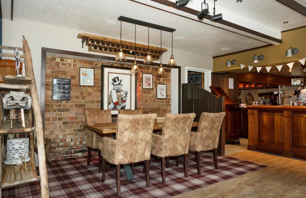 a dining room with a brick wall and a table and chairs at Bacchus Hotel in Sutton on Sea