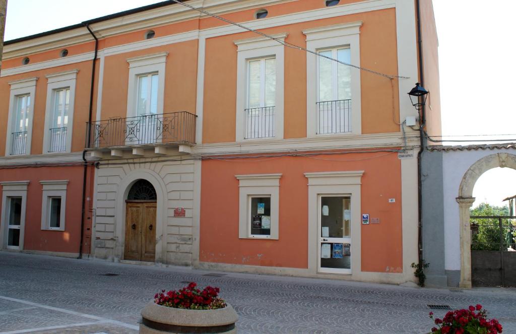 ロッカ・サン・ジョヴァンニにあるPalazzo Croceの花の目の前のオレンジ色の建物