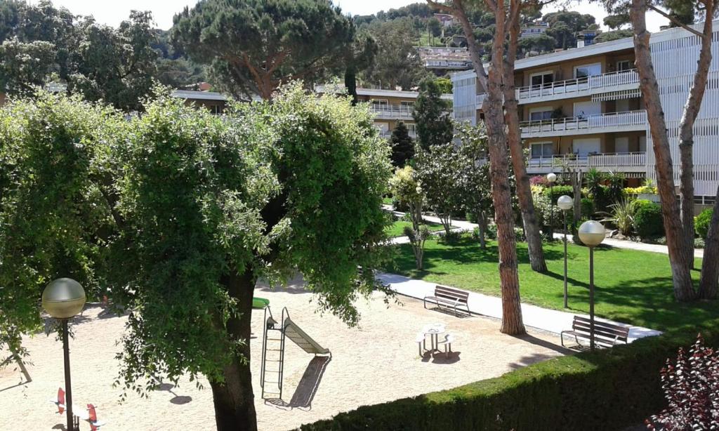 カブリルスにあるApartamento familiarのベンチと木々のある公園と建物