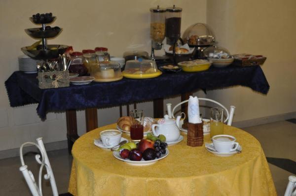 a table with a yellow table cloth with fruit on it at Al-Tair in San Vito lo Capo