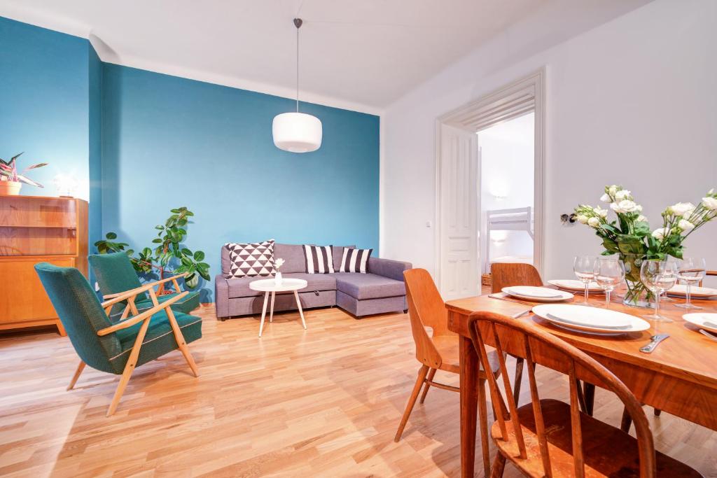 Vachova Apartments في برنو: غرفة معيشة مع طاولة وكراسي وأريكة