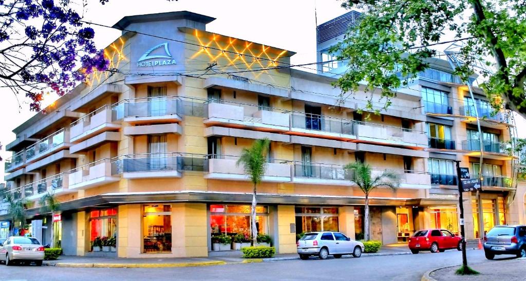 un edificio con coches estacionados frente a él en Hotel Plaza en Colón