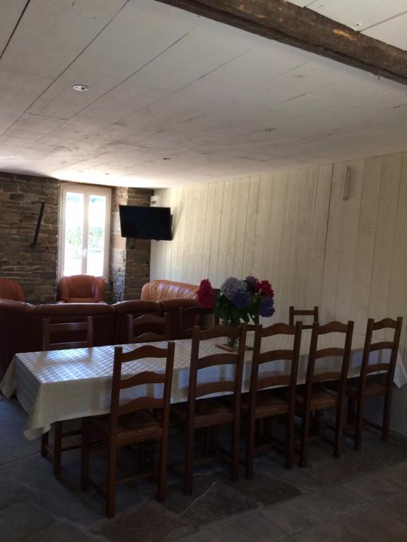 une salle à manger avec une table, des chaises et un canapé dans l'établissement les roulottes de l'airou, à Beauchamps