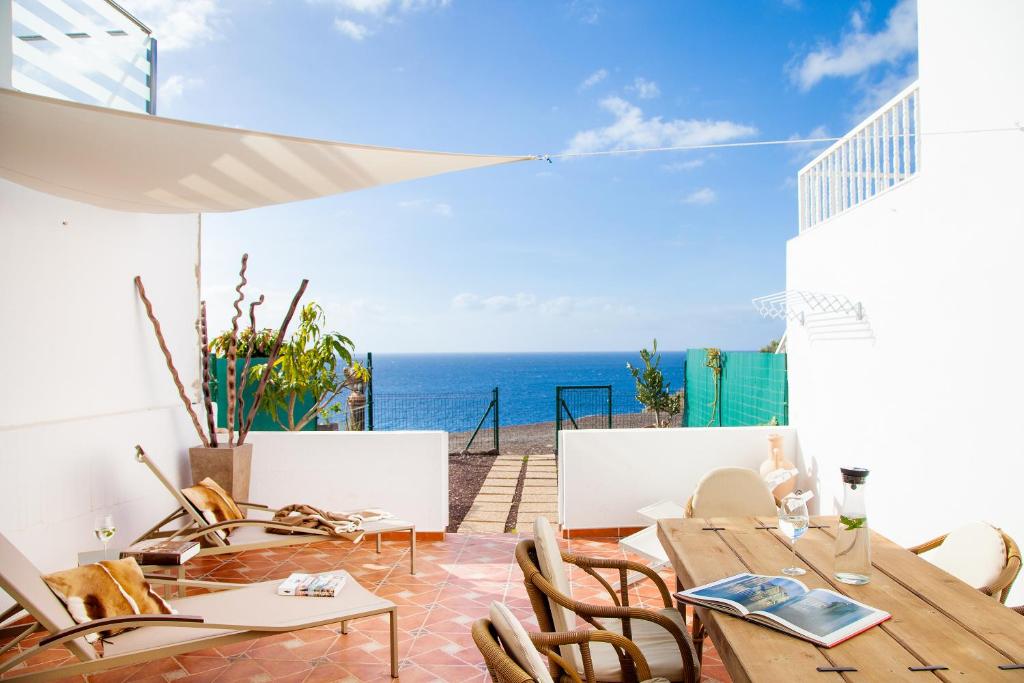 a patio with tables and chairs and a view of the ocean at Jandia Mar in Morro del Jable