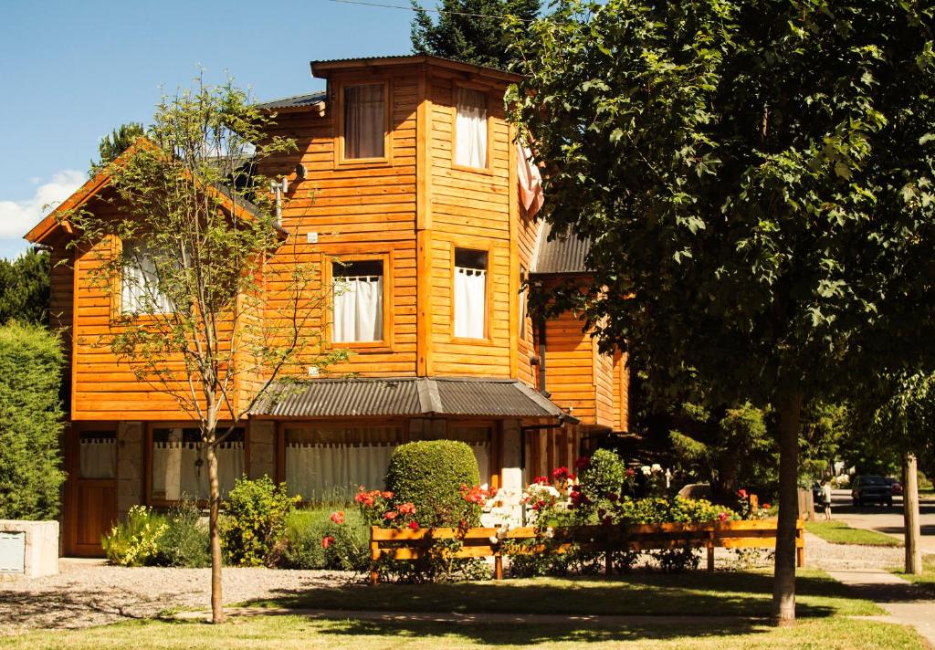 uma casa de madeira com uma mesa em frente em Las Vistas em San Martín de los Andes